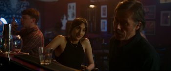 Movie still from “Memory” (2022), directed by Martin Campbell – A woman sitting at a table in front of a man; Medium shot, Over the shoulder angle