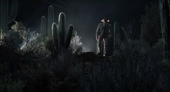 Movie still from “Men in Black” (1997), directed by Barry Sonnenfeld – A man standing in the middle of a field at night; Wide shot, Low angle