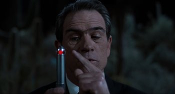 Movie still from “Men in Black” (1997), directed by Barry Sonnenfeld – A person holding a cell phone; Close Up shot, Over the shoulder angle