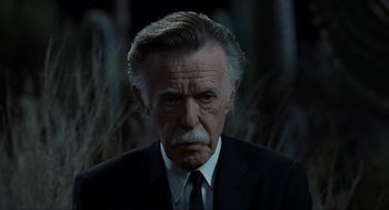 Movie still from “Men in Black” (1997), directed by Barry Sonnenfeld – An older man in a black suit and white tie; Close Up shot, Low angle