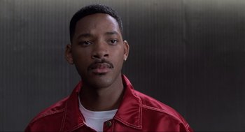Movie still from “Men in Black” (1997), directed by Barry Sonnenfeld – A man in a white shirt and a red jacket; Close Up shot, Low angle