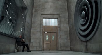 Movie still from “Men in Black” (1997), directed by Barry Sonnenfeld – A person sitting in front of an entrance to a building; Wide shot, High angle
