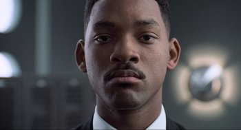 Movie still from “Men in Black” (1997), directed by Barry Sonnenfeld – Will smith in a suit and tie; Close Up shot, Low angle