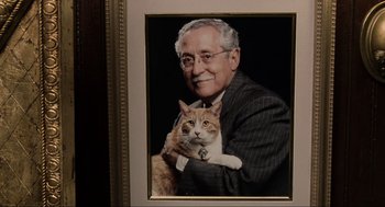 Movie still from “Men in Black” (1997), directed by Barry Sonnenfeld – An old man holding a cat in a picture frame; Extreme Close Up shot, High angle