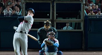 Movie still from “Men in Black” (1997), directed by Barry Sonnenfeld – A man swinging a baseball bat at a game; Wide shot, Low angle