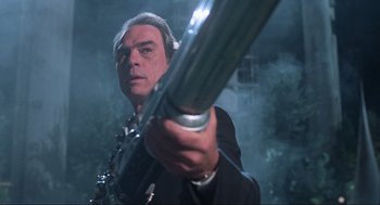 Movie still from “Men in Black” (1997), directed by Barry Sonnenfeld – A man in a suit and tie holding a gun; Close Up shot, Low angle