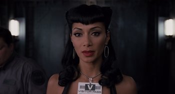 Movie still from “Men in Black 3” (2012), directed by Barry Sonnenfeld – A woman in a black outfit with a visitor pass badge; Close Up shot, Over the shoulder angle