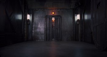 Movie still from “Men in Black 3” (2012), directed by Barry Sonnenfeld – An industrial looking room with a light on the wall; Extreme Wide shot, High angle