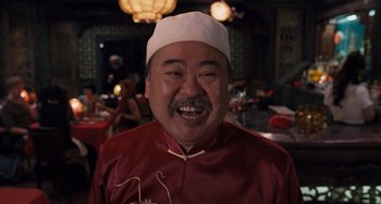 Movie still from “Men in Black 3” (2012), directed by Barry Sonnenfeld – A man in a red shirt and a white hat is smiling for the camera; Close Up shot, Low angle