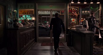 Movie still from “Men in Black 3” (2012), directed by Barry Sonnenfeld – A man walking through a restaurant doorway at night; Wide shot, Over the shoulder angle