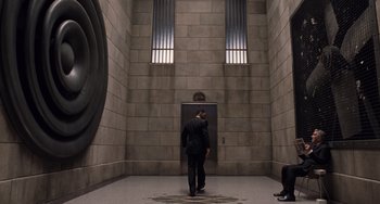Movie still from “Men in Black 3” (2012), directed by Barry Sonnenfeld – A man in a suit walking through a room; Wide shot, Low angle