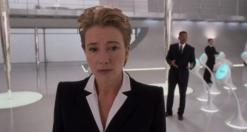 Movie still from “Men in Black 3” (2012), directed by Barry Sonnenfeld – A woman in a suit and tie standing next to a man in a suit and tie; Close Up shot, Over the shoulder angle
