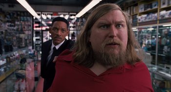 Movie still from “Men in Black 3” (2012), directed by Barry Sonnenfeld – A man with long hair and a beard standing next to a man with long hair; Close Up shot, Over the shoulder angle