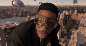 Movie still from “Men in Black 3” (2012), directed by Barry Sonnenfeld – A man in a suit and goggles is looking at the camera; Extreme Close Up shot, Low angle