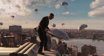 Movie still from “Men in Black 3” (2012), directed by Barry Sonnenfeld – A man on a ledge holding a fish in the air; Extreme Wide shot, Low angle