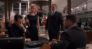 Movie still from “Men in Black 3” (2012), directed by Barry Sonnenfeld – A group of people sitting around a table; Medium shot, Over the shoulder angle