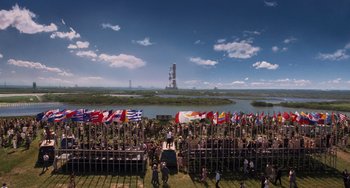 Movie still from “Men in Black 3” (2012), directed by Barry Sonnenfeld – A crowd of people standing in front of a body of water; Extreme Wide shot, High angle