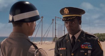 Movie still from “Men in Black 3” (2012), directed by Barry Sonnenfeld – Two men in military uniforms standing next to each other on the beach; Close Up shot, Over the shoulder angle