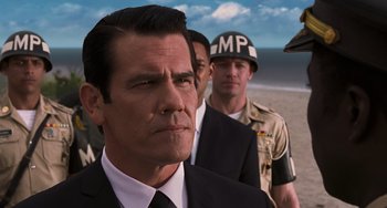 Movie still from “Men in Black 3” (2012), directed by Barry Sonnenfeld – A group of men standing next to each other on top of a beach; Close Up shot, Low angle