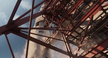Movie still from “Men in Black 3” (2012), directed by Barry Sonnenfeld – A tall metal structure with a building in the background; Extreme Wide shot, Overhead angle