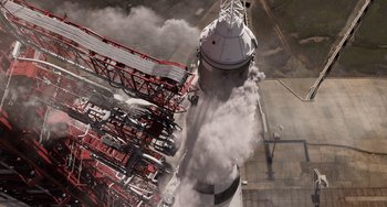 Movie still from “Men in Black 3” (2012), directed by Barry Sonnenfeld – An aerial view of a tower with smoke coming out of it; Extreme Wide shot, Overhead angle