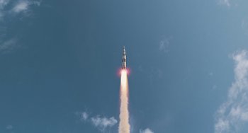 Movie still from “Men in Black 3” (2012), directed by Barry Sonnenfeld – A rocket is flying through the air with a cloud behind it; Extreme Wide shot, Low angle