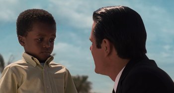 Movie still from “Men in Black 3” (2012), directed by Barry Sonnenfeld – A man in a suit talking to a boy in a dress shirt; Close Up shot, Over the shoulder angle