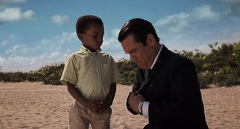 Movie still from “Men in Black 3” (2012), directed by Barry Sonnenfeld – A man in a suit and a young boy in a yellow shirt; Medium shot, Over the shoulder angle