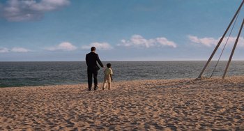 Movie still from “Men in Black 3” (2012), directed by Barry Sonnenfeld – A man and a child on the beach looking out at the ocean; Extreme Wide shot, High angle
