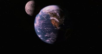 Movie still from “Men in Black II” (2002), directed by Barry Sonnenfeld – An earth and moon in a space with stars in the background; Extreme Wide shot, High angle