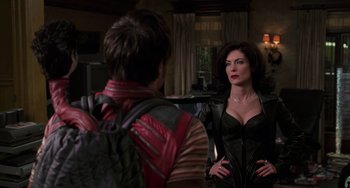 Movie still from “Men in Black II” (2002), directed by Barry Sonnenfeld – A man and a woman are standing in front of a mirror; Medium shot, Over the shoulder angle