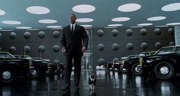 Movie still from “Men in Black II” (2002), directed by Barry Sonnenfeld – A man and a dog in a room; Wide shot, Low angle