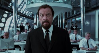 Movie still from “Men in Black II” (2002), directed by Barry Sonnenfeld – A man in a suit and tie in front of a group of people; Close Up shot, Low angle