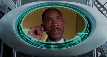 Movie still from “Men in Black II” (2002), directed by Barry Sonnenfeld – A person holding a cell phone to their ear; Close Up shot, High angle