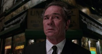 Movie still from “Men in Black II” (2002), directed by Barry Sonnenfeld – An older man in a suit and tie looking to his left; Close Up shot, Low angle