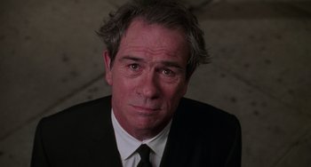 Movie still from “Men in Black II” (2002), directed by Barry Sonnenfeld – A person wearing a suit and tie; Close Up shot, Low angle