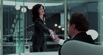 Movie still from “Men in Black II” (2002), directed by Barry Sonnenfeld – A woman in a black leather jacket holding a remote control; Medium shot, Over the shoulder angle