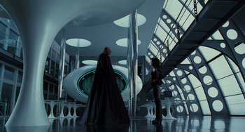 Movie still from “Men in Black II” (2002), directed by Barry Sonnenfeld – Two people in a room with futuristic architecture; Wide shot, Low angle