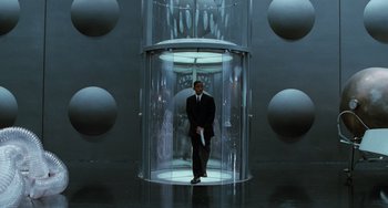 Movie still from “Men in Black II” (2002), directed by Barry Sonnenfeld – A man in a suit standing in front of an elevator; Wide shot, High angle
