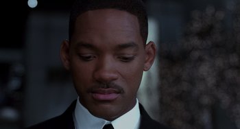 Movie still from “Men in Black II” (2002), directed by Barry Sonnenfeld – A person wearing a suit and tie; Close Up shot, Low angle