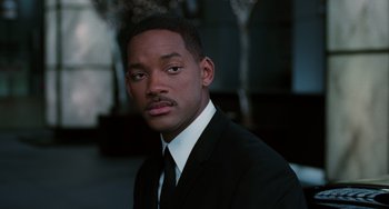 Movie still from “Men in Black II” (2002), directed by Barry Sonnenfeld – A man wearing a suit and tie; Close Up shot, Over the shoulder angle