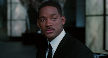 Movie still from “Men in Black II” (2002), directed by Barry Sonnenfeld – A man wearing a suit and tie; Close Up shot, Over the shoulder angle
