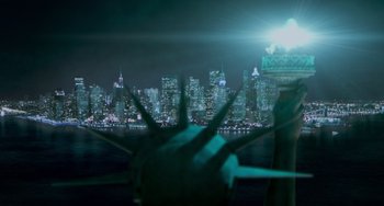 Movie still from “Men in Black II” (2002), directed by Barry Sonnenfeld – The statue of liberty is lit up at night in new york city; Extreme Wide shot, High angle