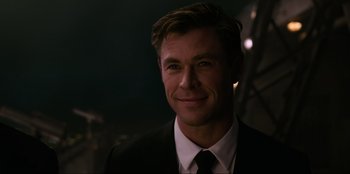 Movie still from “Men in Black: International” (2019), directed by F. Gary Gray – A person wearing a suit and tie; Close Up shot, Over the shoulder angle