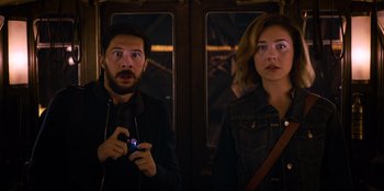 Movie still from “Men in Black: International” (2019), directed by F. Gary Gray – A man and a woman standing next to each other on a train; Medium shot, Over the shoulder angle