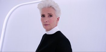 Movie still from “Men in Black: International” (2019), directed by F. Gary Gray – An older woman with white hair wearing a black suit; Close Up shot, Low angle