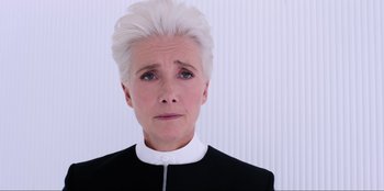 Movie still from “Men in Black: International” (2019), directed by F. Gary Gray – An older woman with white hair wearing a black jacket; Close Up shot, Low angle