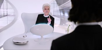 Movie still from “Men in Black: International” (2019), directed by F. Gary Gray – An older woman sitting in front of a mirror in front of another woman; Medium shot, Over the shoulder angle