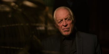 Movie still from “Men in Black: International” (2019), directed by F. Gary Gray – An older man wearing a black shirt and a black jacket; Close Up shot, Low angle