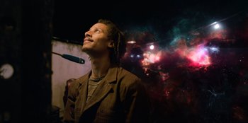 Movie still from “Men in Black: International” (2019), directed by F. Gary Gray – A man with dreadlocks is looking up into the sky; Medium shot, Low angle